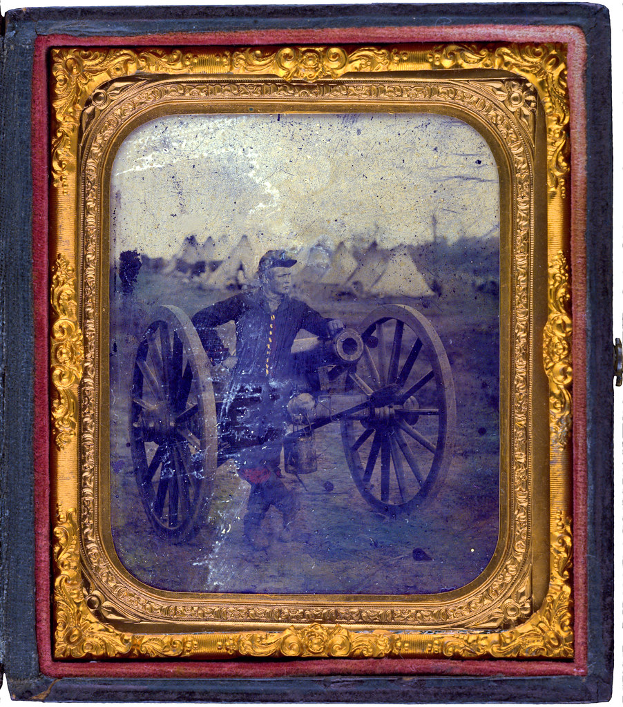 Unidentified soldier in Union uniform standing with Napoleon cannon in front of encampment Unidentified soldier in Union uniform standing with Napoleon cannon in front of encampment